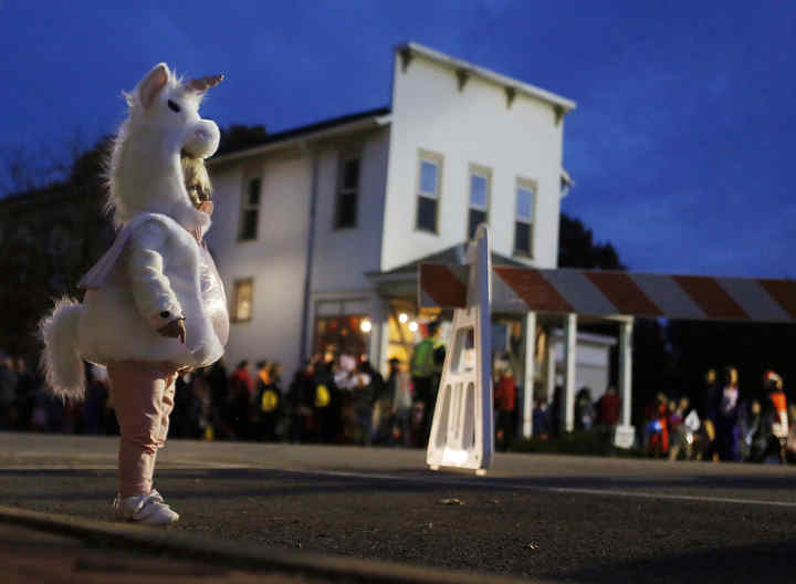 Emma Wood dressed as a unicorn takes in the Haunted Village square in Pickerington. Emma and her family were enjoying the community halloween that featured haunted tours of the museum and other venues in old Pickerington.   (Eric Albrecht / The Columbus Dispatch)